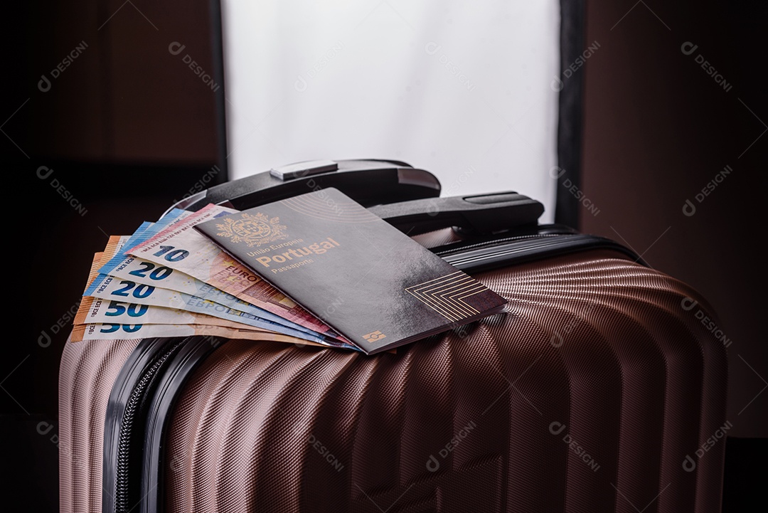 Passaporte sobre uma mala de viagem ao lado de dinheiro
