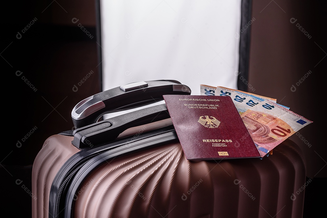 Passaporte sobre uma mala de viagem ao lado de dinheiro