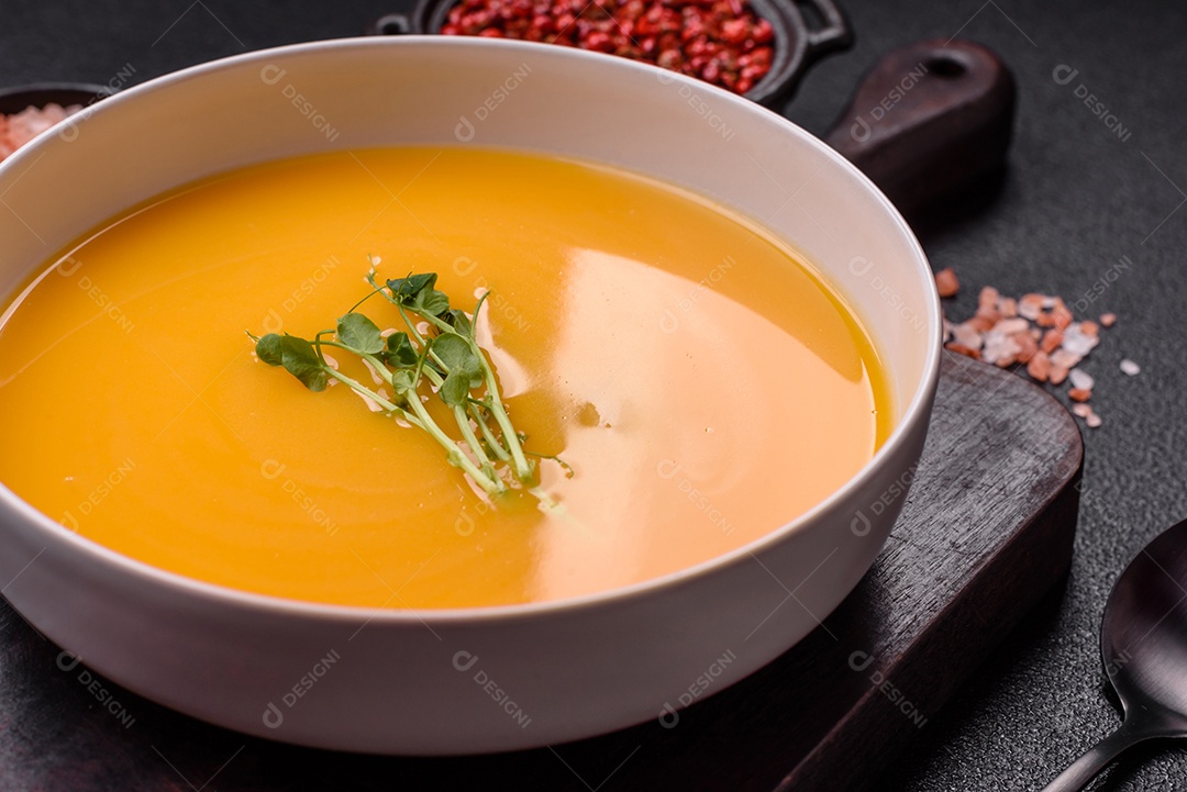 Sopa de abóbora e cenoura em uma mesa de concreto