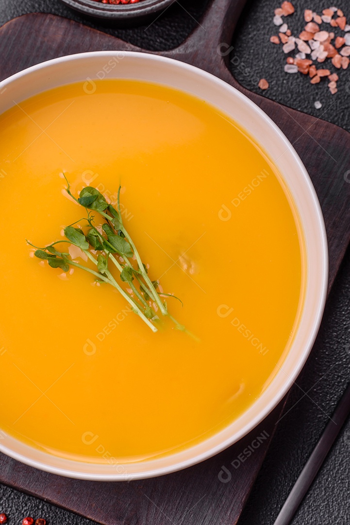 Sopa de abóbora e cenoura em uma mesa de concreto