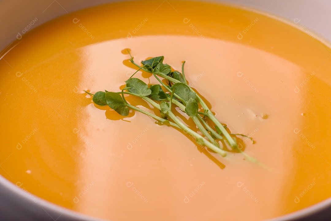 Sopa de abóbora e cenoura em uma mesa de concreto