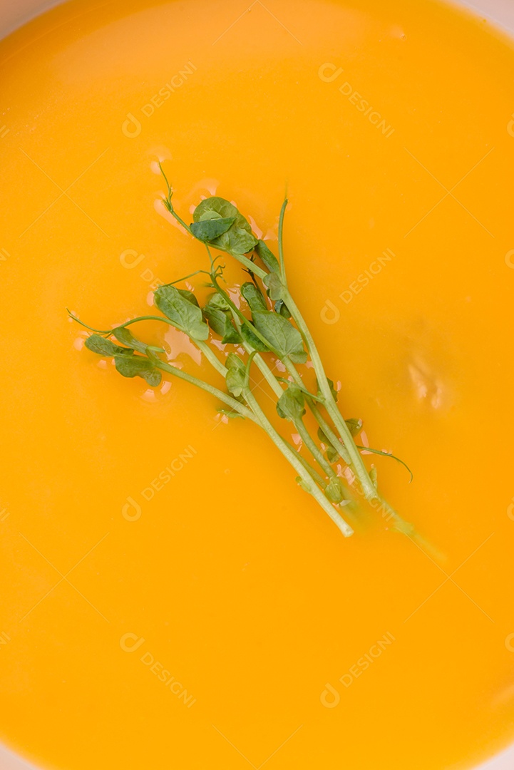 Sopa de abóbora e cenoura em uma mesa de concreto