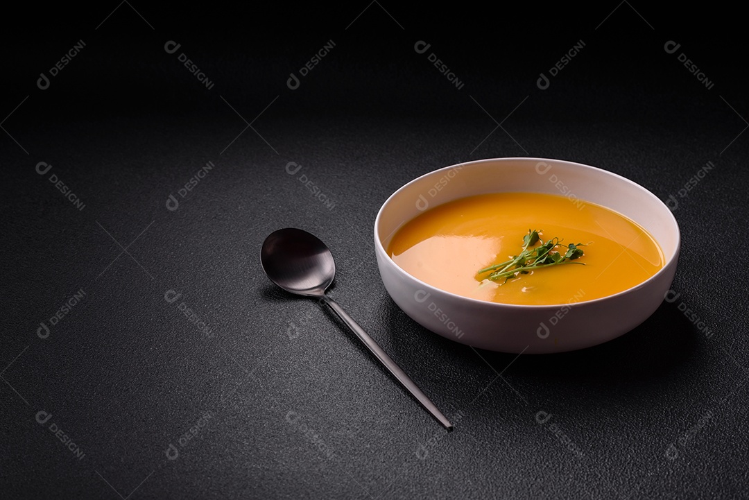 Sopa de abóbora e cenoura em uma mesa de concreto
