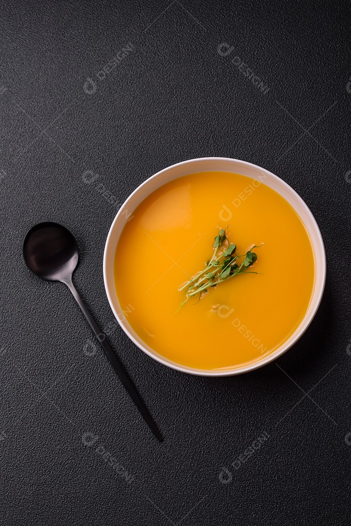 Sopa de abóbora e cenoura em uma mesa de concreto