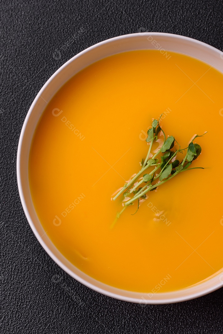 Sopa de abóbora e cenoura em uma mesa de concreto