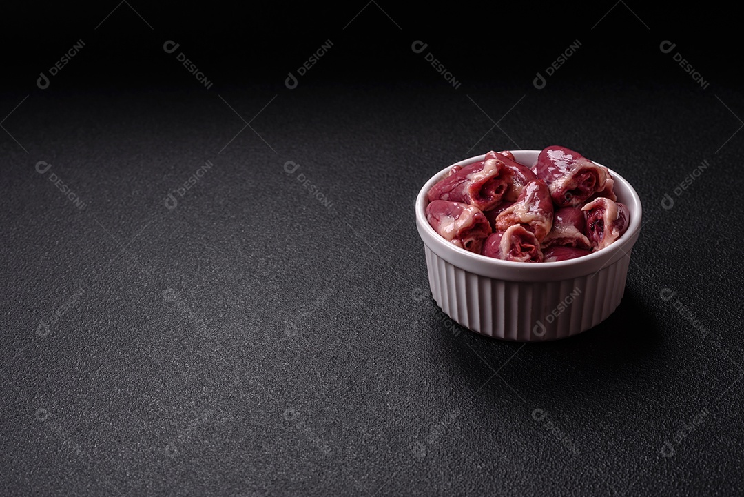 Corações de galinha frescos em uma mesa de concreto