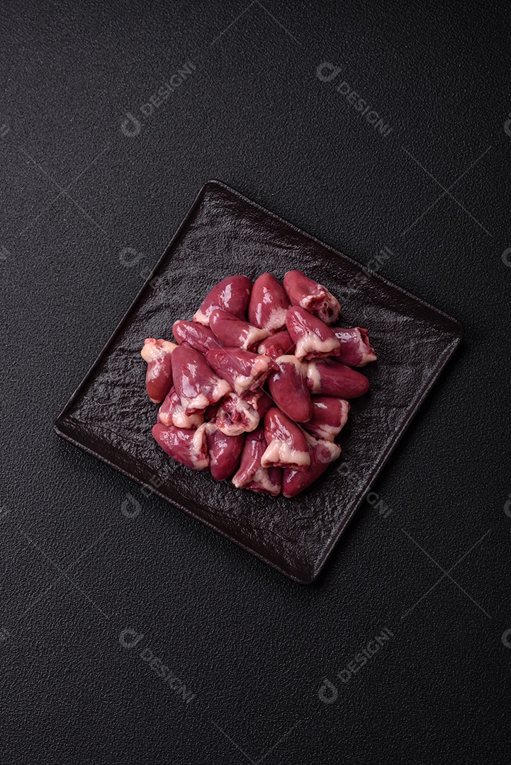 Corações de galinha frescos em uma mesa de concreto