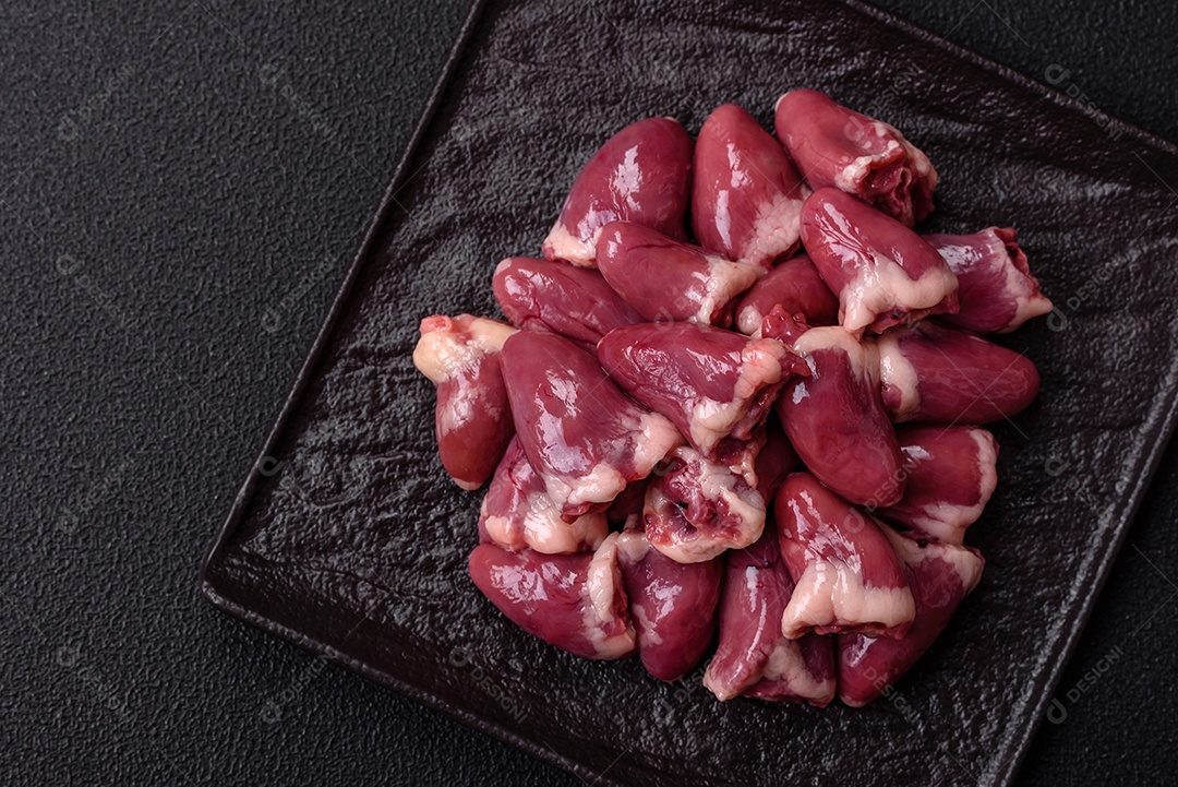 Corações de galinha frescos em uma mesa de concreto