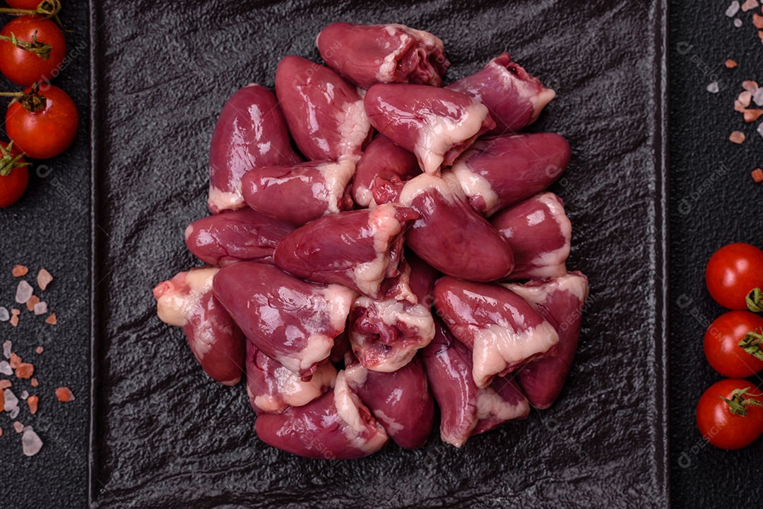 Corações de galinha frescos em uma mesa de concreto