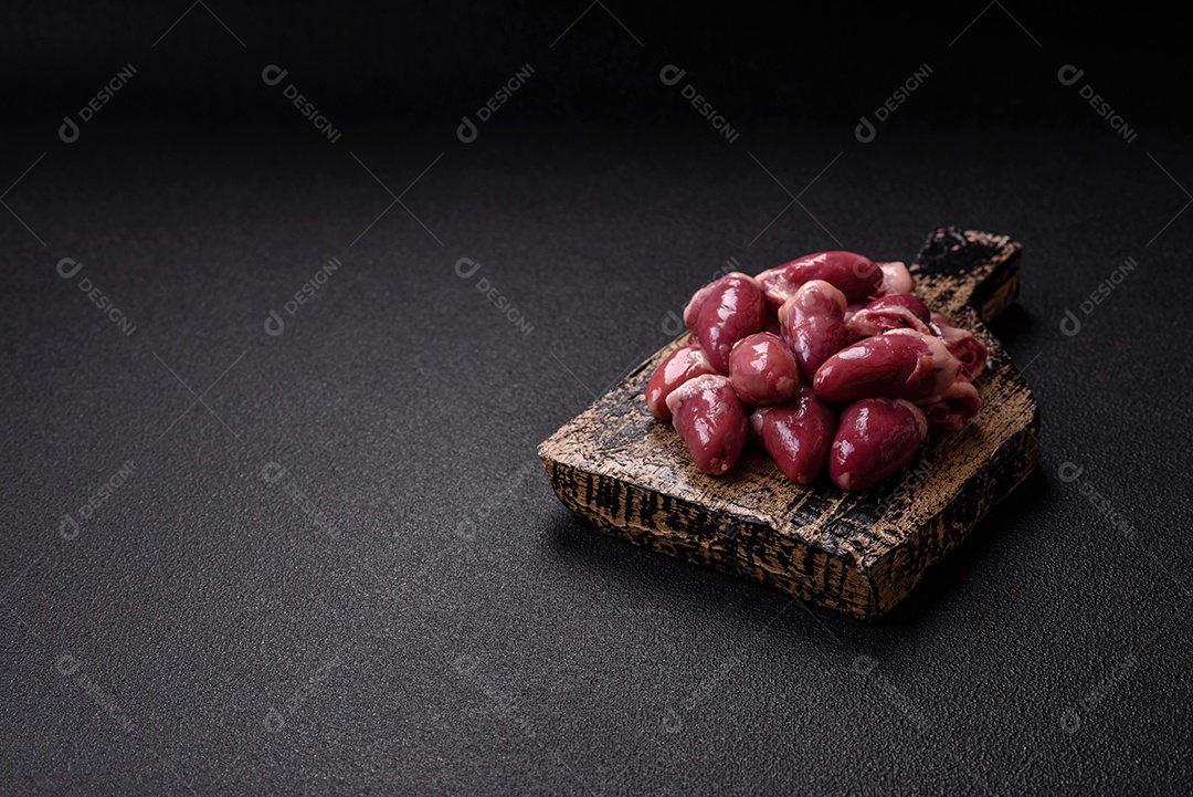 Corações de galinha frescos em uma mesa de concreto