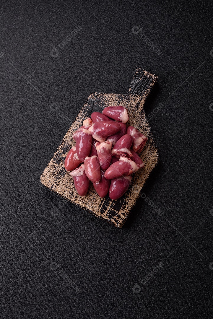 Corações de galinha frescos em uma mesa de concreto