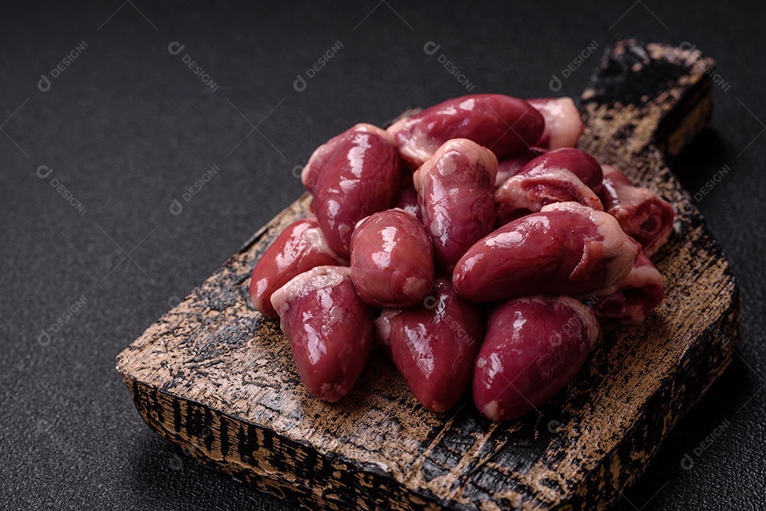 Corações de galinha frescos em uma mesa de concreto