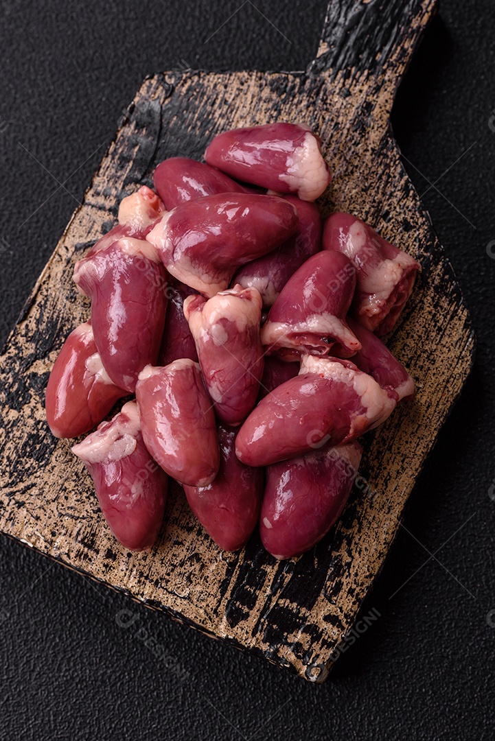 Corações de galinha frescos em uma mesa de concreto