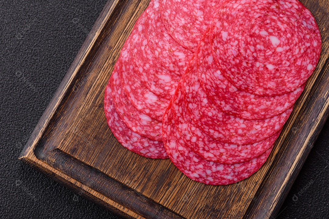 Delicioso salame fatiado em uma mesa de concreto