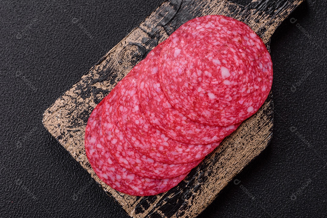 Delicioso salame fatiado em uma mesa de concreto