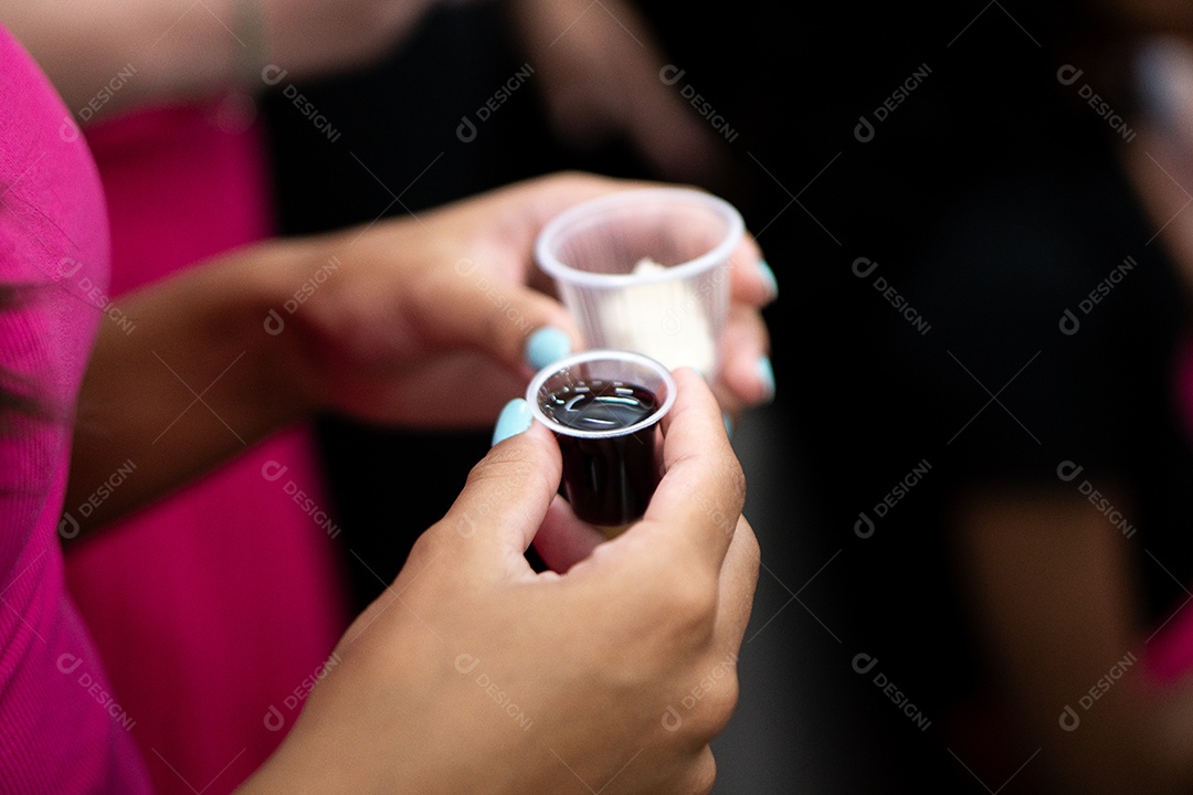 Mão de uma mulher segurando santa ceia sob uma igreja