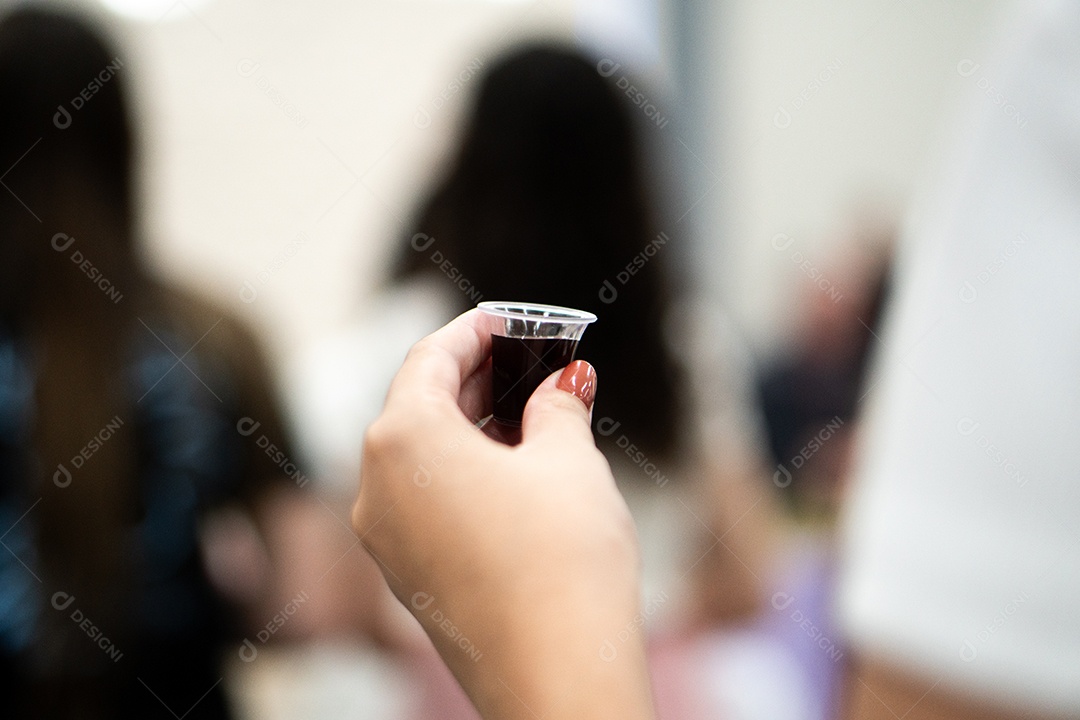 Mão de uma mulher segurando santa ceia sob uma igreja