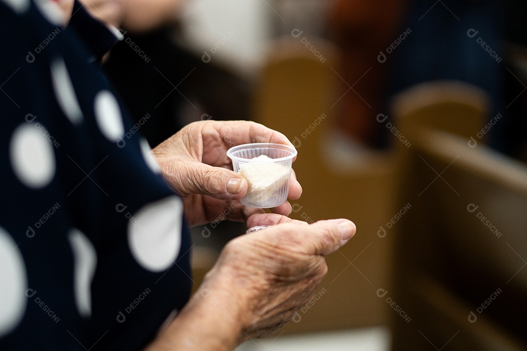 Mão de uma mulher segurando santa ceia sob uma igreja