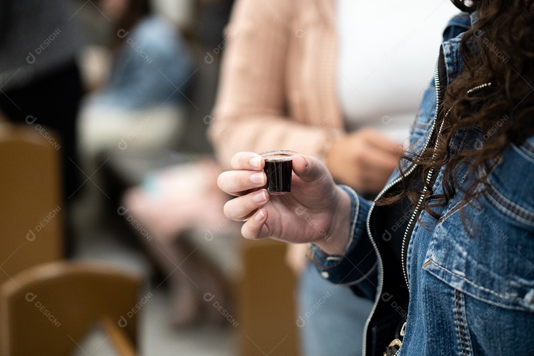 Mão de uma mulher segurando santa ceia sob uma igreja