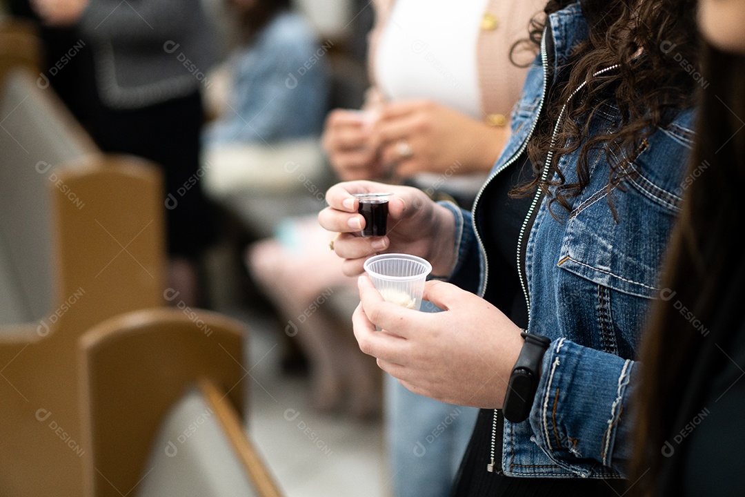 Mão de uma mulher segurando santa ceia sob uma igreja