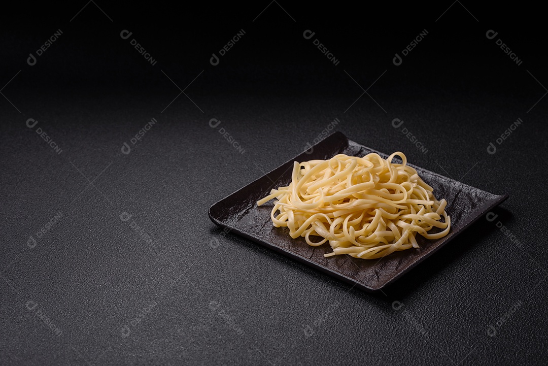 Macarrão de arroz com feijão, carne, molho de tomate, especiarias e ervas em um fundo de concreto escuro
