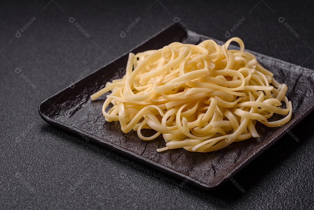 Macarrão de arroz com feijão, carne, molho de tomate, especiarias e ervas em um fundo de concreto escuro