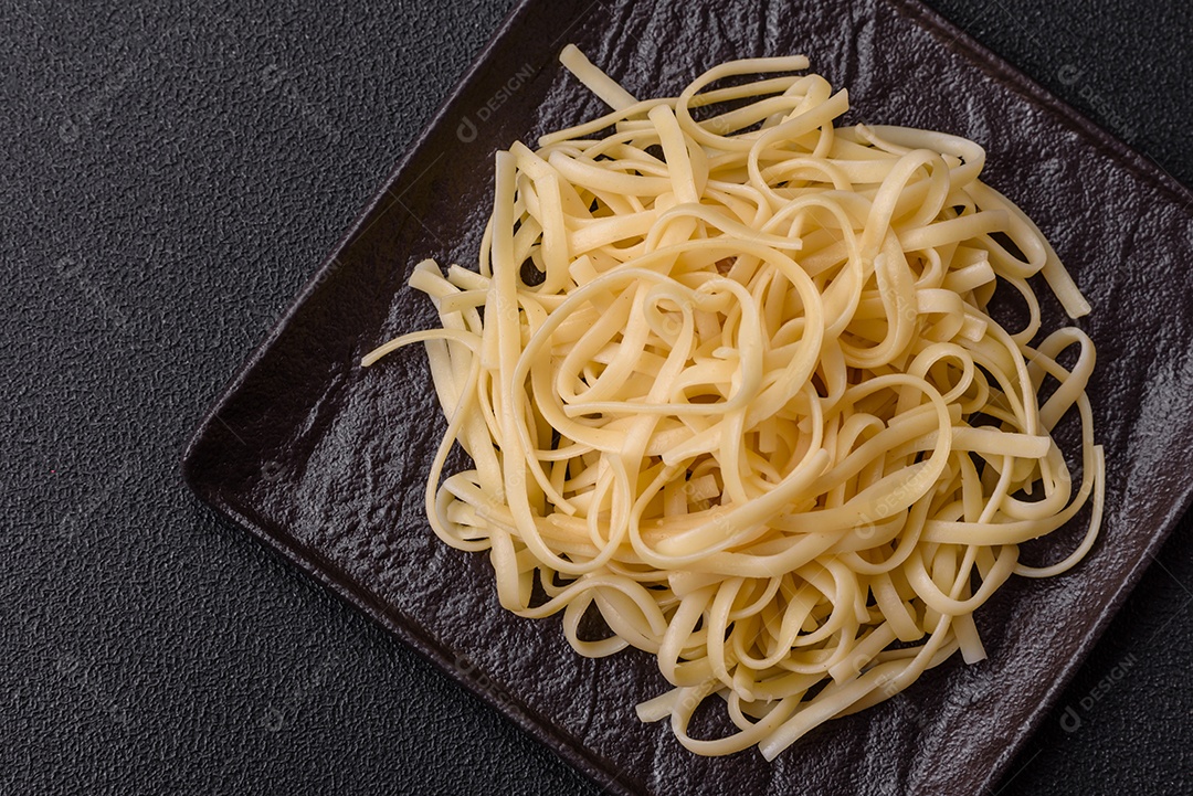 Macarrão de arroz com feijão, carne, molho de tomate, especiarias e ervas em um fundo de concreto escuro