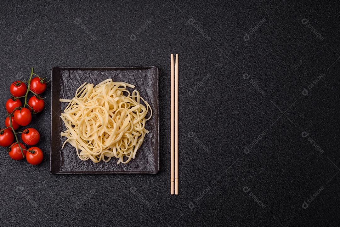 Macarrão de arroz com feijão, carne, molho de tomate, especiarias e ervas em um fundo de concreto escuro