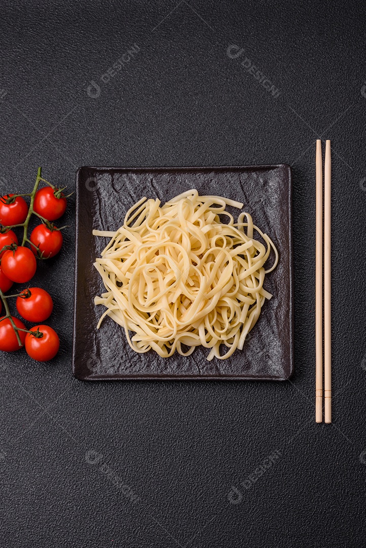Macarrão de arroz com feijão, carne, molho de tomate, especiarias e ervas em um fundo de concreto escuro