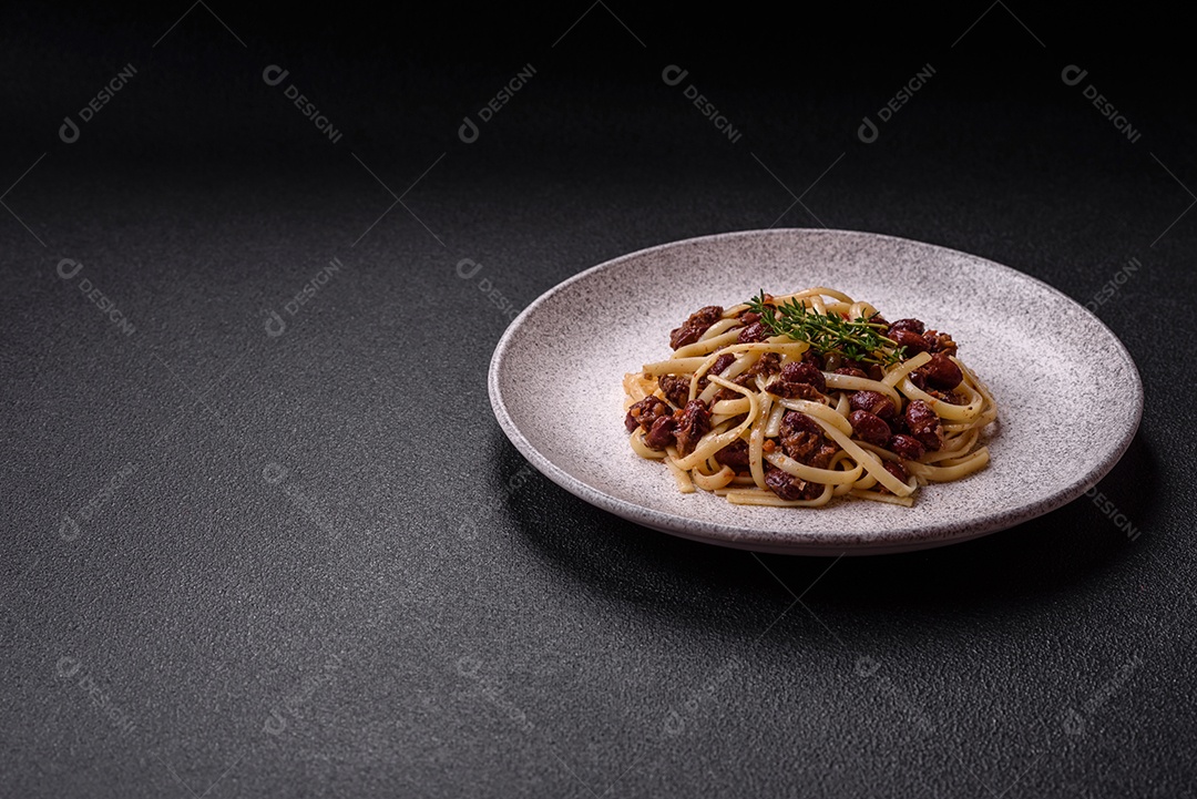 Macarrão de arroz com feijão, carne, molho de tomate, especiarias e ervas em um fundo de concreto escuro