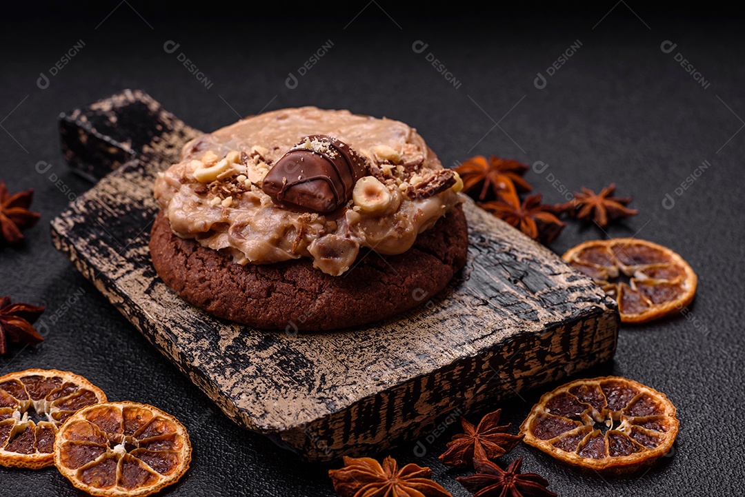 Biscoitos doces de aveia com creme de manteiga ou manteiga de amendoim e nozes em fundo de concreto escuro