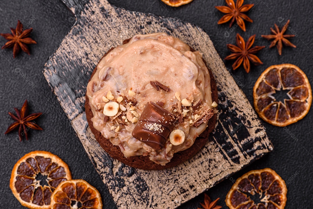 Biscoitos doces de aveia com creme de manteiga ou manteiga de amendoim e nozes em fundo de concreto escuro