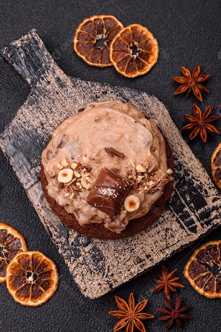 Biscoitos doces de aveia com creme de manteiga ou manteiga de amendoim e nozes em fundo de concreto escuro
