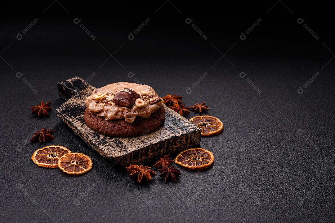 Biscoitos doces de aveia com creme de manteiga ou manteiga de amendoim e nozes em fundo de concreto escur