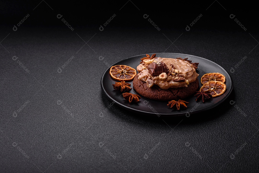 Biscoitos doces de aveia com creme de manteiga ou manteiga de amendoim e nozes em fundo de concreto escuro