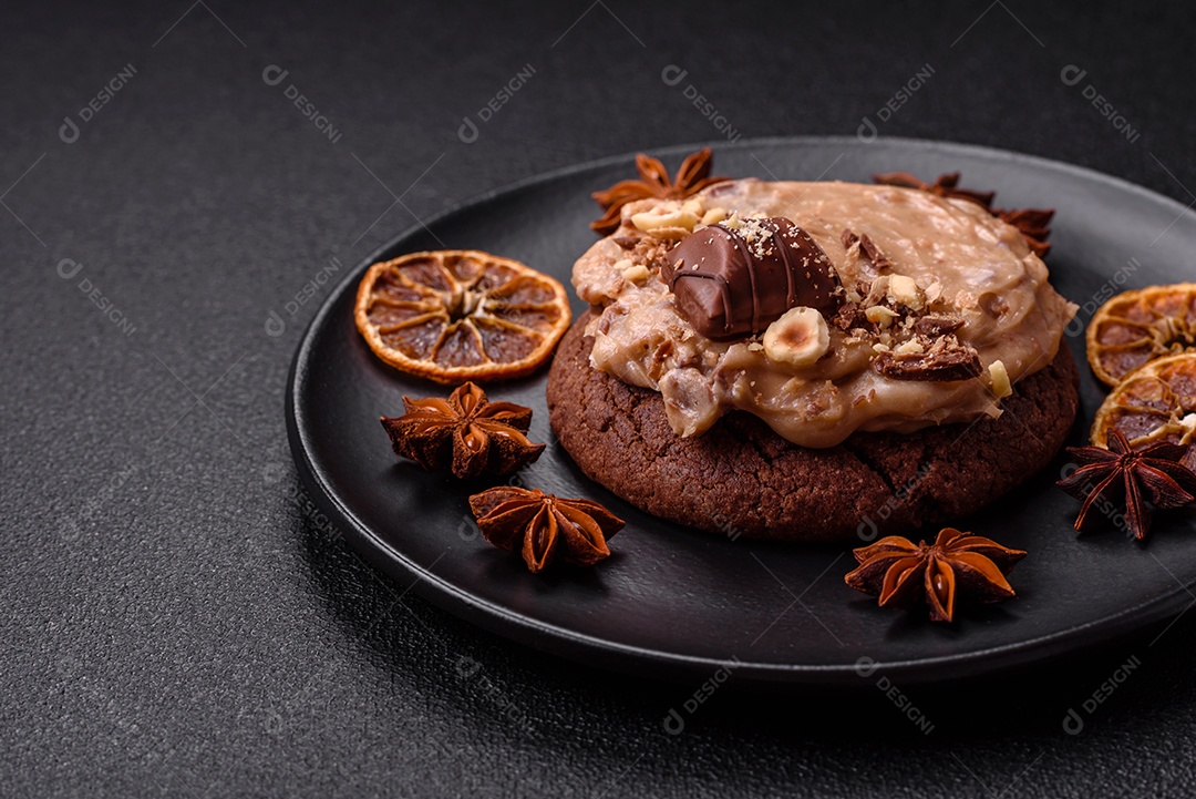 Biscoitos doces de aveia com creme de manteiga ou manteiga de amendoim e nozes em fundo de concreto escuro