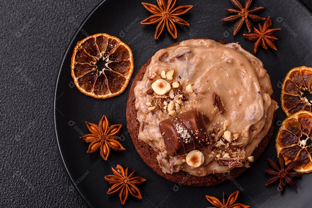 Biscoitos doces de aveia com creme de manteiga ou manteiga de amendoim e nozes em fundo de concreto escuro
