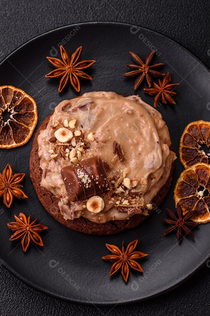 Biscoitos doces de aveia com creme de manteiga ou manteiga de amendoim e nozes em fundo de concreto escuro