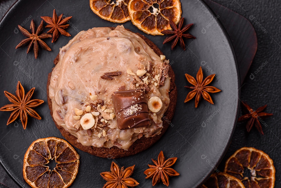 Biscoitos doces de aveia com creme de manteiga ou manteiga de amendoim e nozes em fundo de concreto escuro