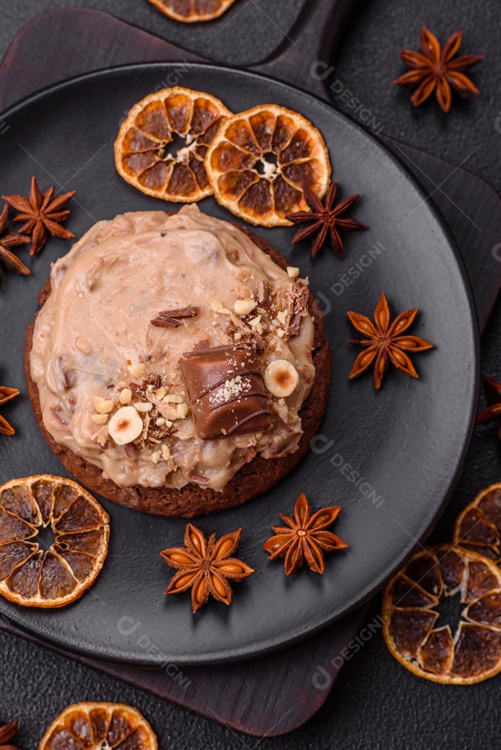 Biscoitos doces de aveia com creme de manteiga ou manteiga de amendoim e nozes em fundo de concreto escuro