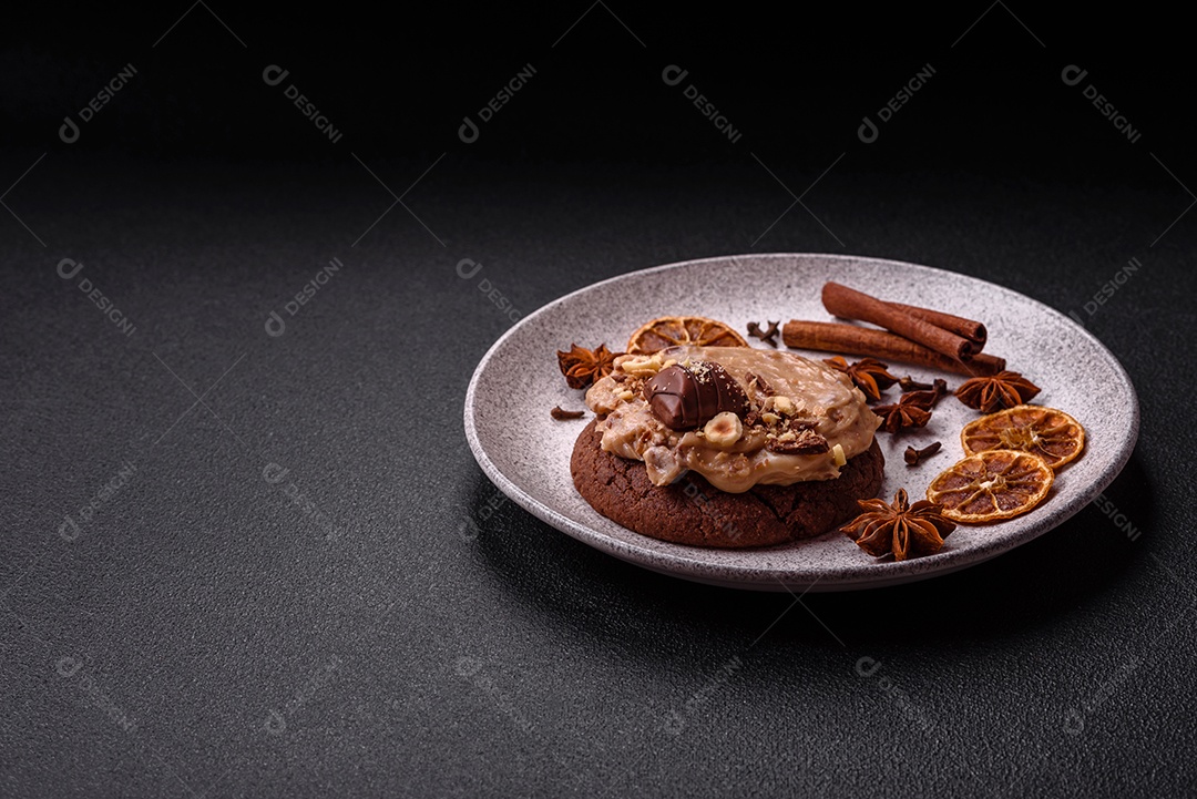 Biscoitos doces de aveia com creme de manteiga ou manteiga de amendoim e nozes em fundo de concreto escuro