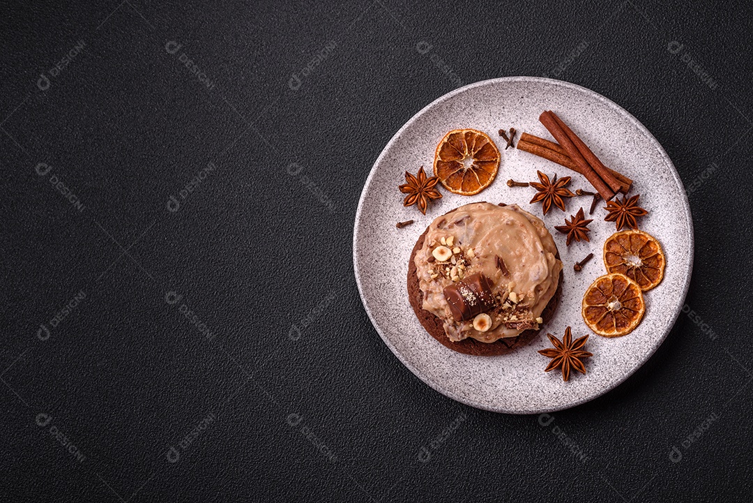 Biscoitos doces de aveia com creme de manteiga ou manteiga de amendoim e nozes em fundo de concreto escuro