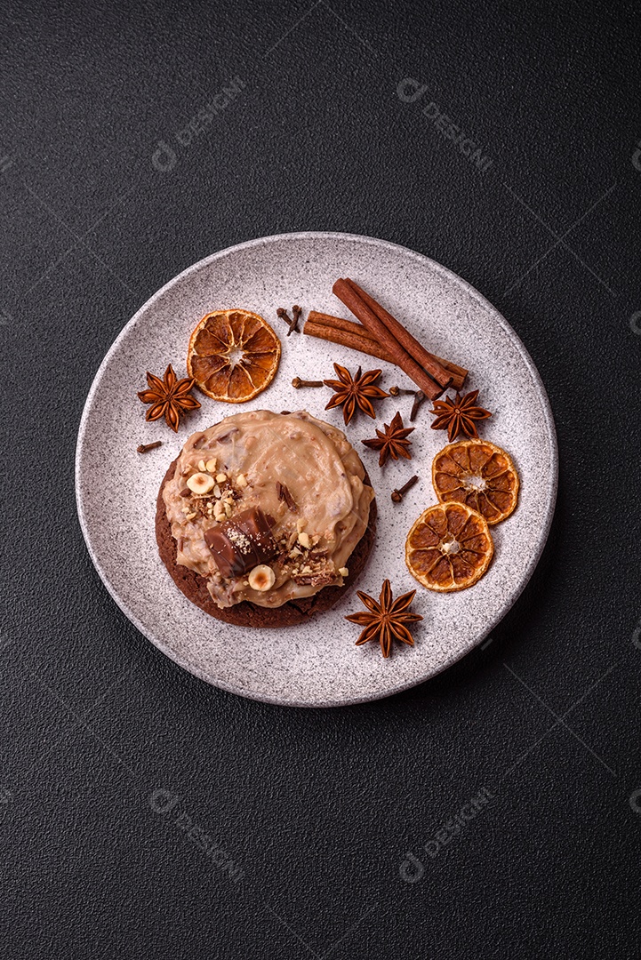 Biscoitos doces de aveia com creme de manteiga ou manteiga de amendoim e nozes em fundo de concreto escuro