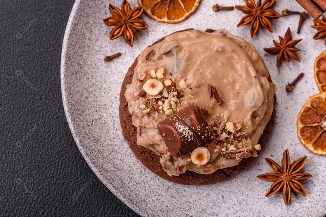 Biscoitos doces de aveia com creme de manteiga ou manteiga de amendoim e nozes em fundo de concreto escuro