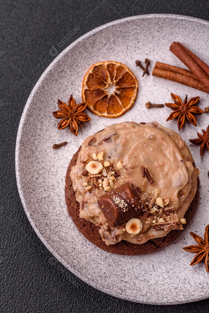 Biscoitos doces de aveia com creme de manteiga ou manteiga de amendoim e nozes em fundo de concreto escuro