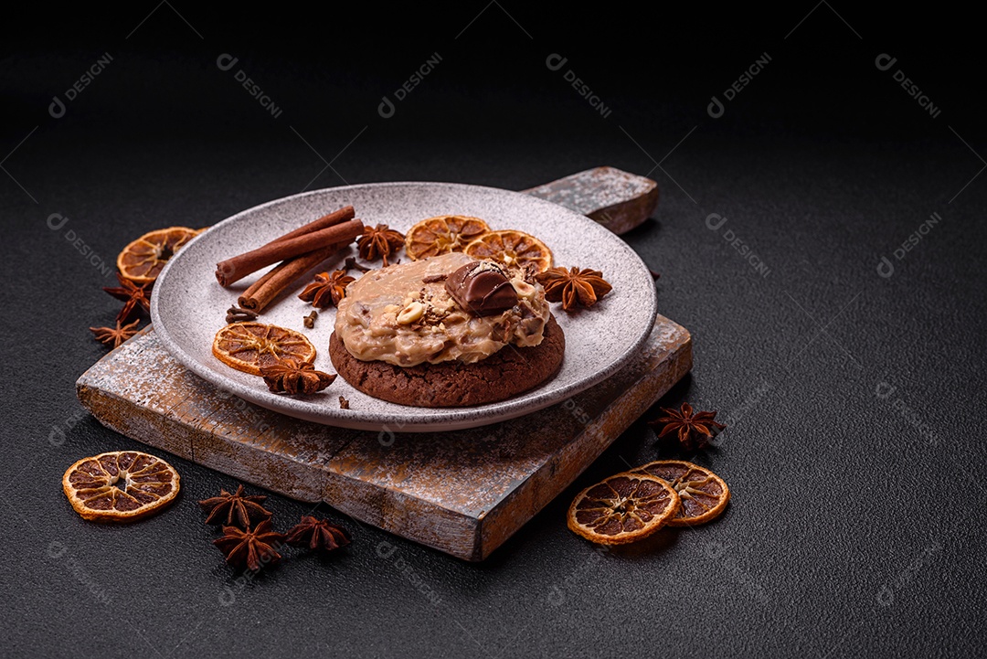 Biscoitos doces de aveia com creme de manteiga ou manteiga de amendoim e nozes em fundo de concreto escuro