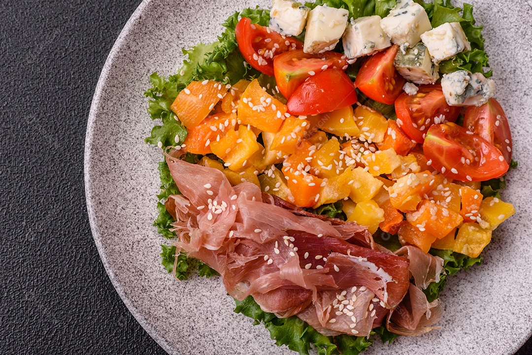Salada apetitosa com presunto, abóbora assada, queijo, alface, tomate e sementes de gergelim