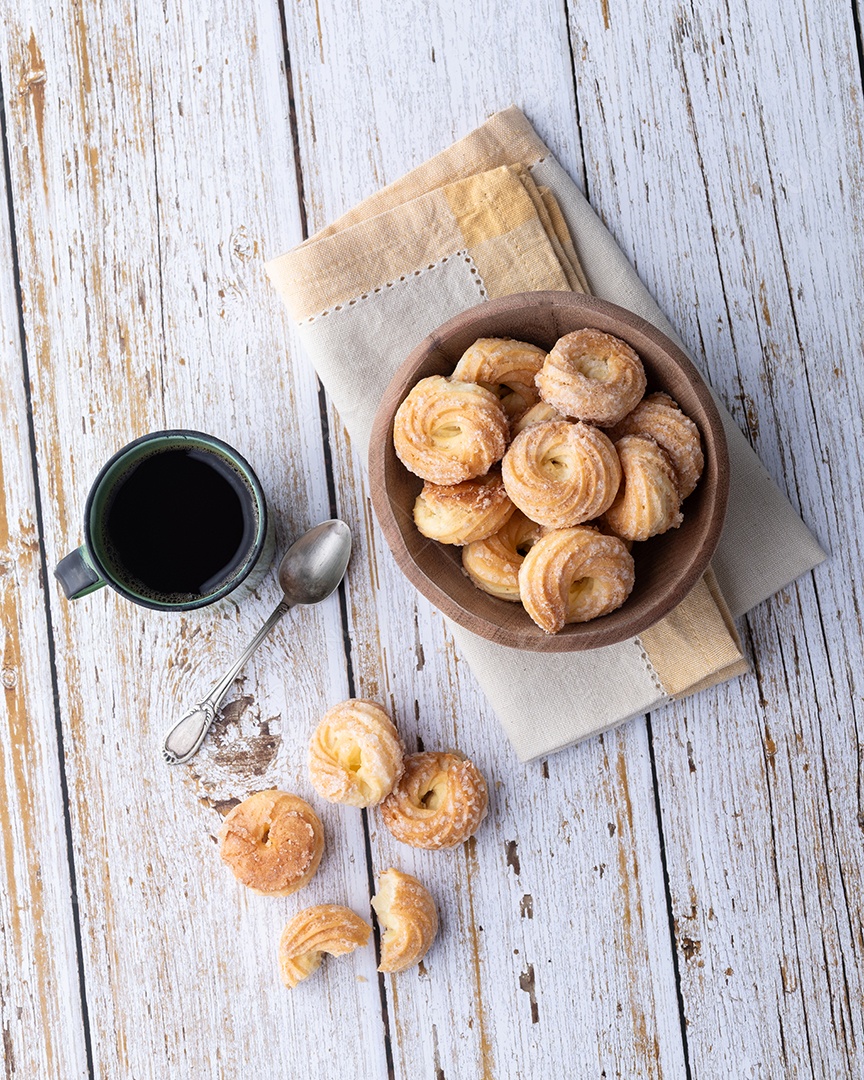 A imagem mostra biscoitos amanteigados, frequentemente acompanhados de uma bebida quente como café