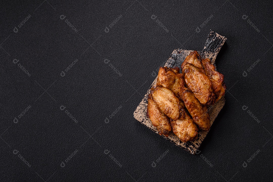 Asas de frango assadas saborosas em uma mesa de concreto