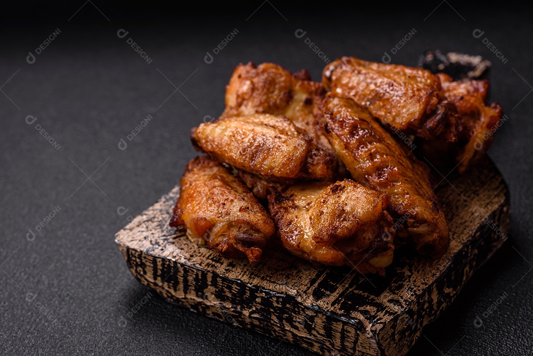 Asas de frango assadas saborosas em uma mesa de concreto